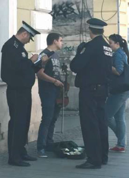 Polițiști locali discutând cu un artist local al Clujului